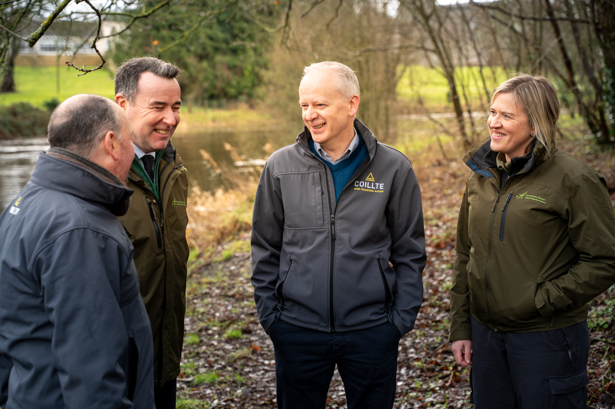 Coillte and IFI staff chatting in a forest beneath trees