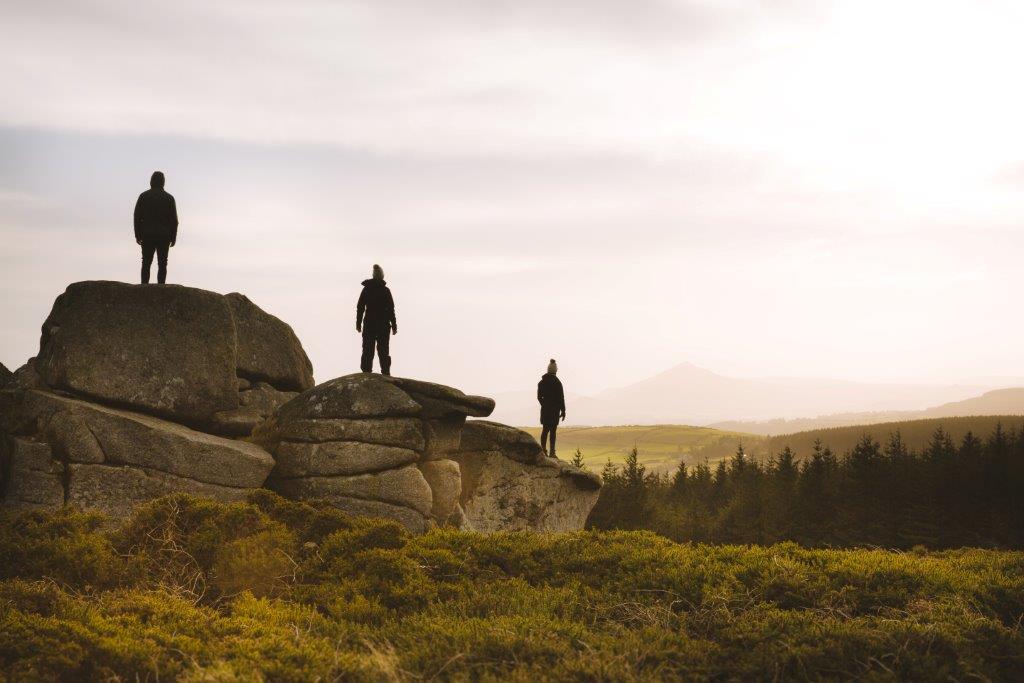 Picture of three people standing on three rocks