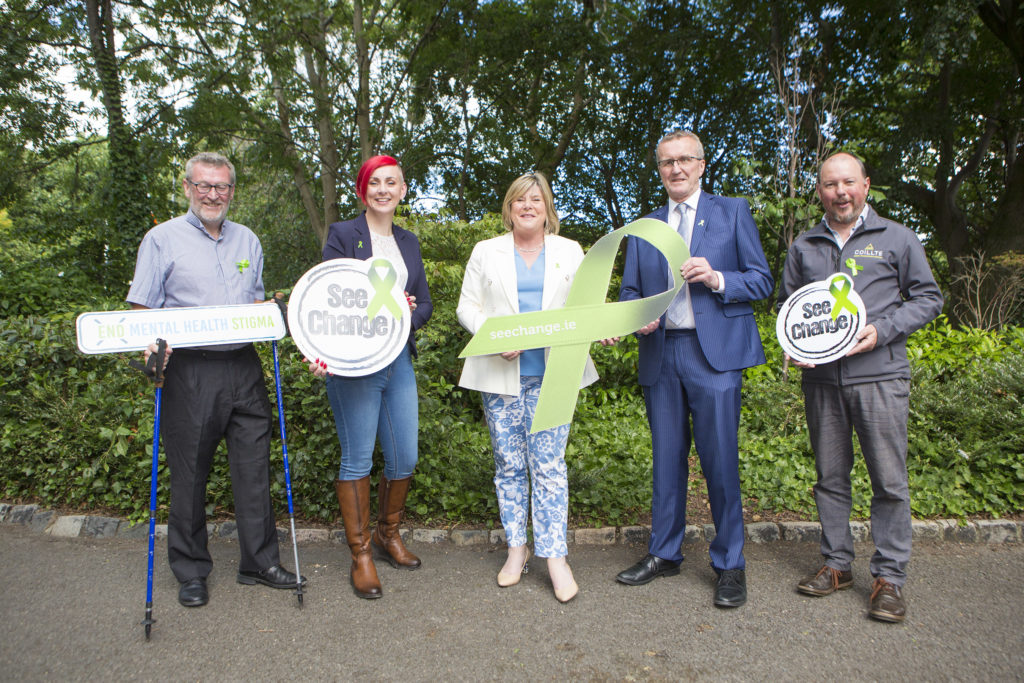 Martin Rogan, Barbara Brennan, Minister Mary Butler TD, Tim Cullinan and Pat Neville posing for a photo holding up signs to promote the Let's Walk and Talk mental health awareness campaign