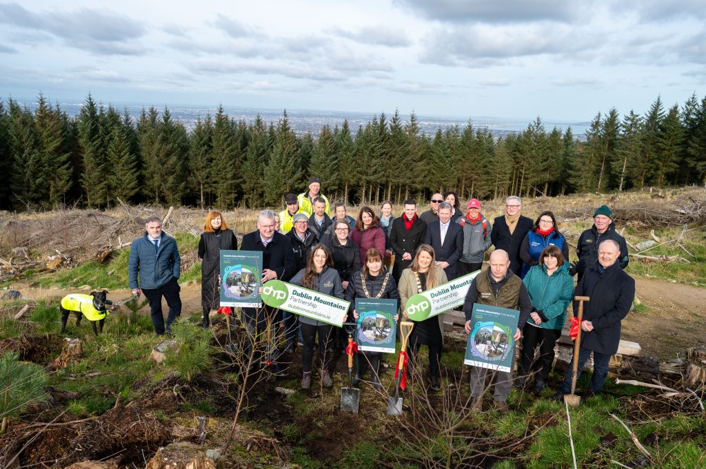 Group shot of people standing in a forest holding Dublin Mountain Partnership signs