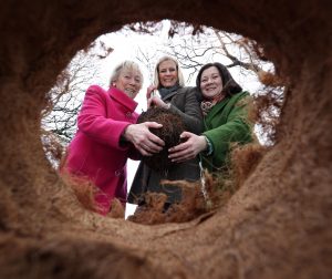 Eanna Ni Lamhna, President of the Tree Council of Ireland, MInister Pippa Hackett and Coillte CEO Imelda Hurley holding a young tree about to be planted in the ground